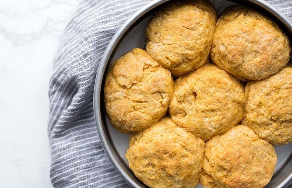 Sweet potato biscuits close together in a cake pan, fresh out of the oven.