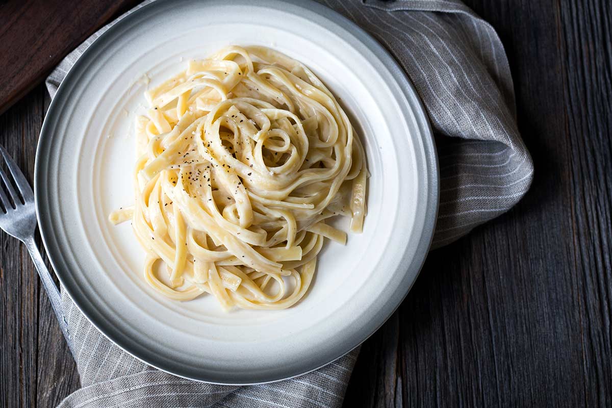 Fettuccine with Cauliflower Alfredo Sauce on a plate set over a napkin.
