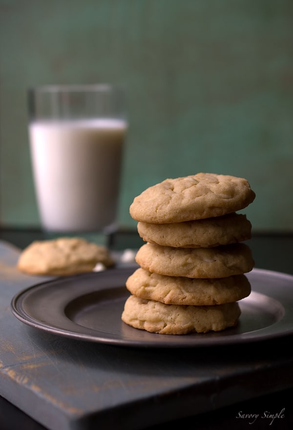 Irish cream white chocolate chip cookies ~ Savory Simple ~ www.savorysimple.net #recipe Homemade chocolate chip cookies with white chocolate chips and Baileys Irish Cream Liqueur, set on a silver plate with a green background.