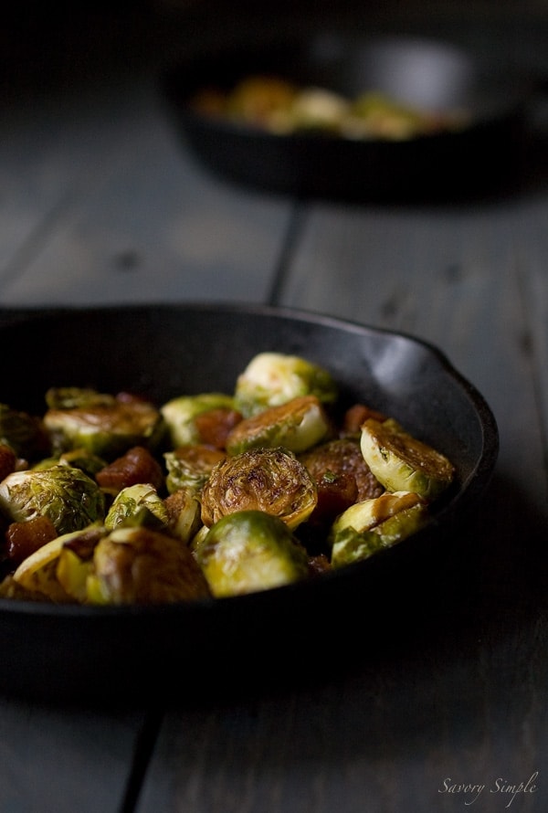 A photo of brown sugar bacon brussels sprouts in a cast iron skillet