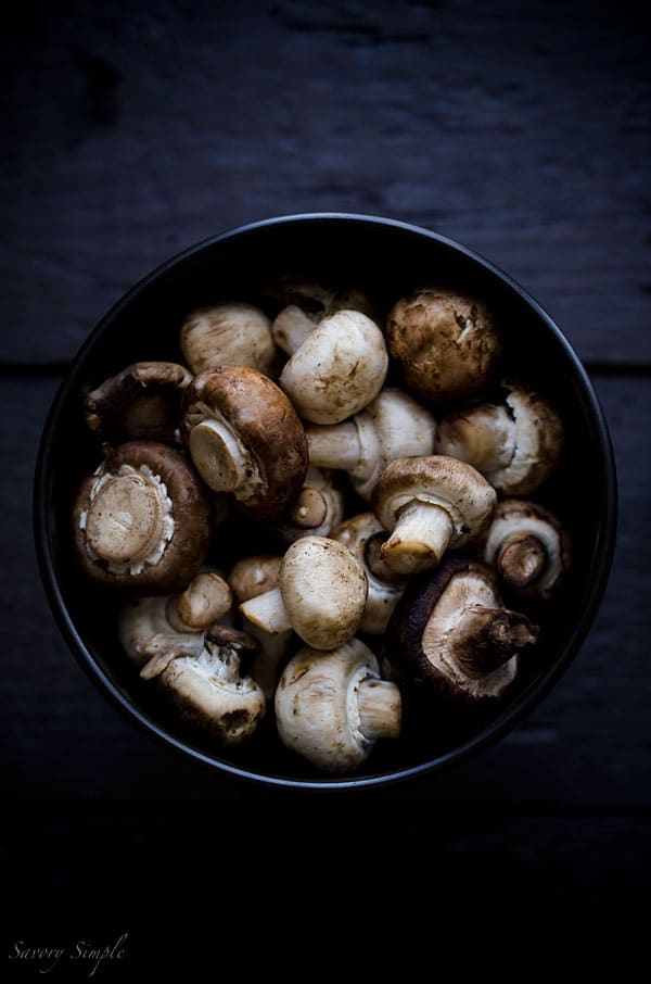 A macro photo of button mushrooms being prepped for asian dumplings.