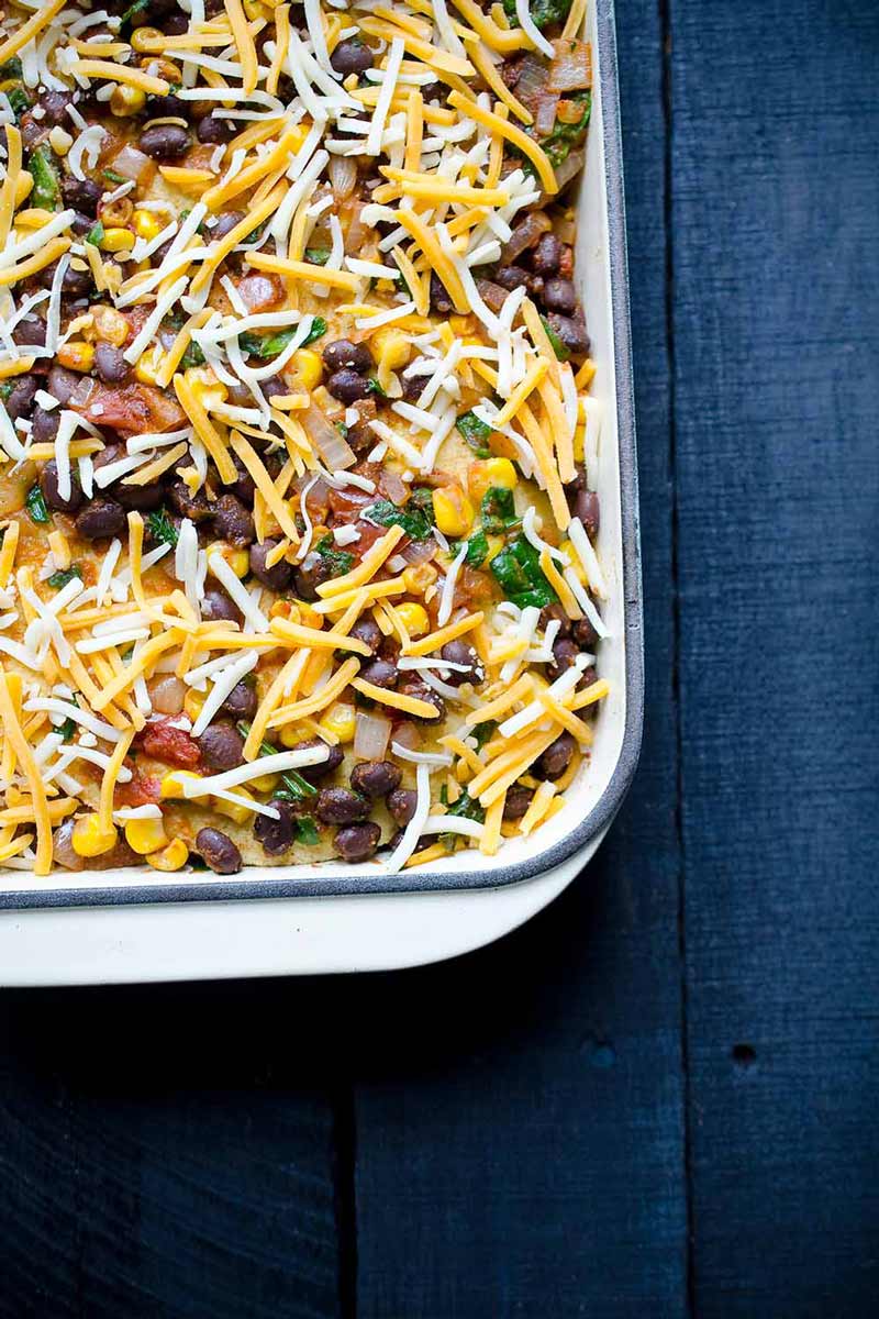 A photo of Mexican tortilla casserole in a casserole dish, about to be baked.