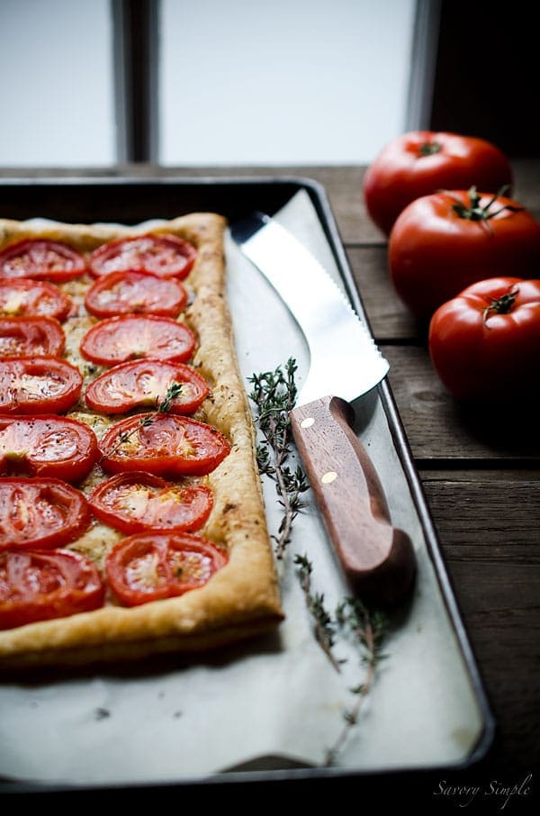 This simple tomato tart is made with only 4 ingredients: tomatoes, puff pastry, roasted garlic and fresh thyme. Get this seasonal, flavorful appetizer recipe from SavorySimple.net