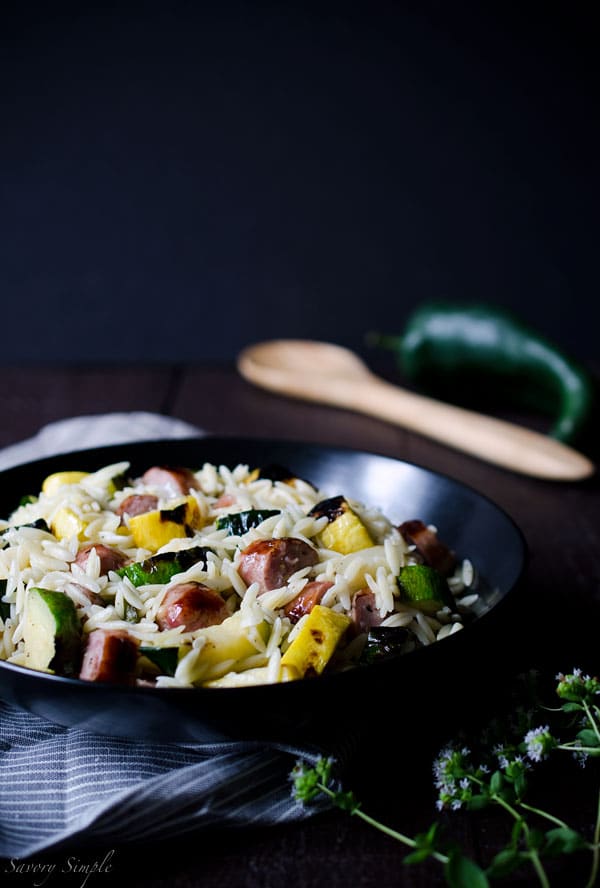 This Grilled Italian Sausage and Vegetable Orzo Salad is all about summer grilling! Smokey, charred vegetables add a ton of flavor to this meaty pasta salad. It's ready in just 30 minutes. Get the recipe from SavorySimple.net.