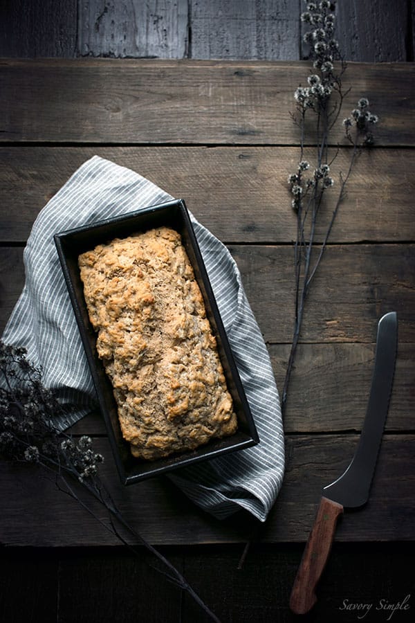 An overhead shot of beer bread next to a serrated knife.