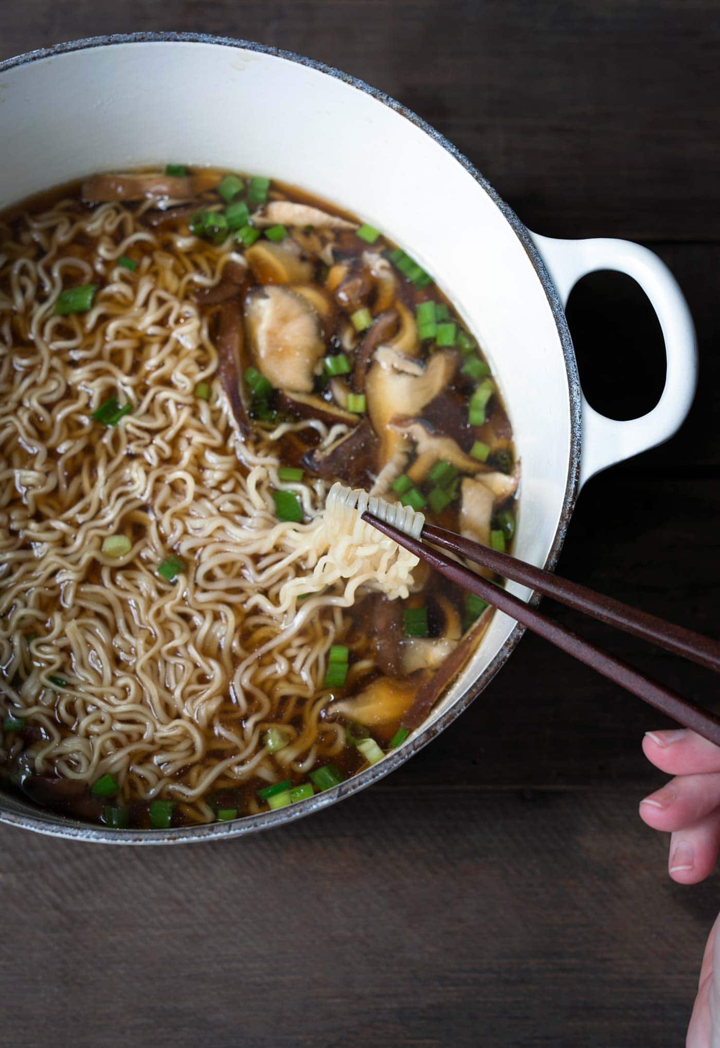 easy homemade ramen in a Dutch oven with chopsticks lifting the noodles
