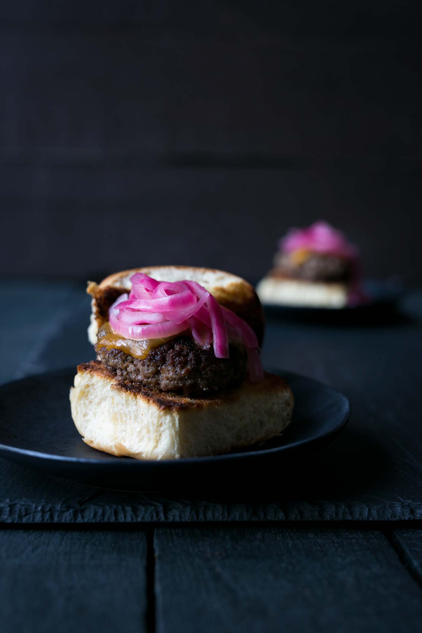 These Cheeseburger Sliders with Quick Pickled Onions are the PERFECT combinations of flavors and texture. They are also so easy to make! Get the recipe from SavorySimple.net.