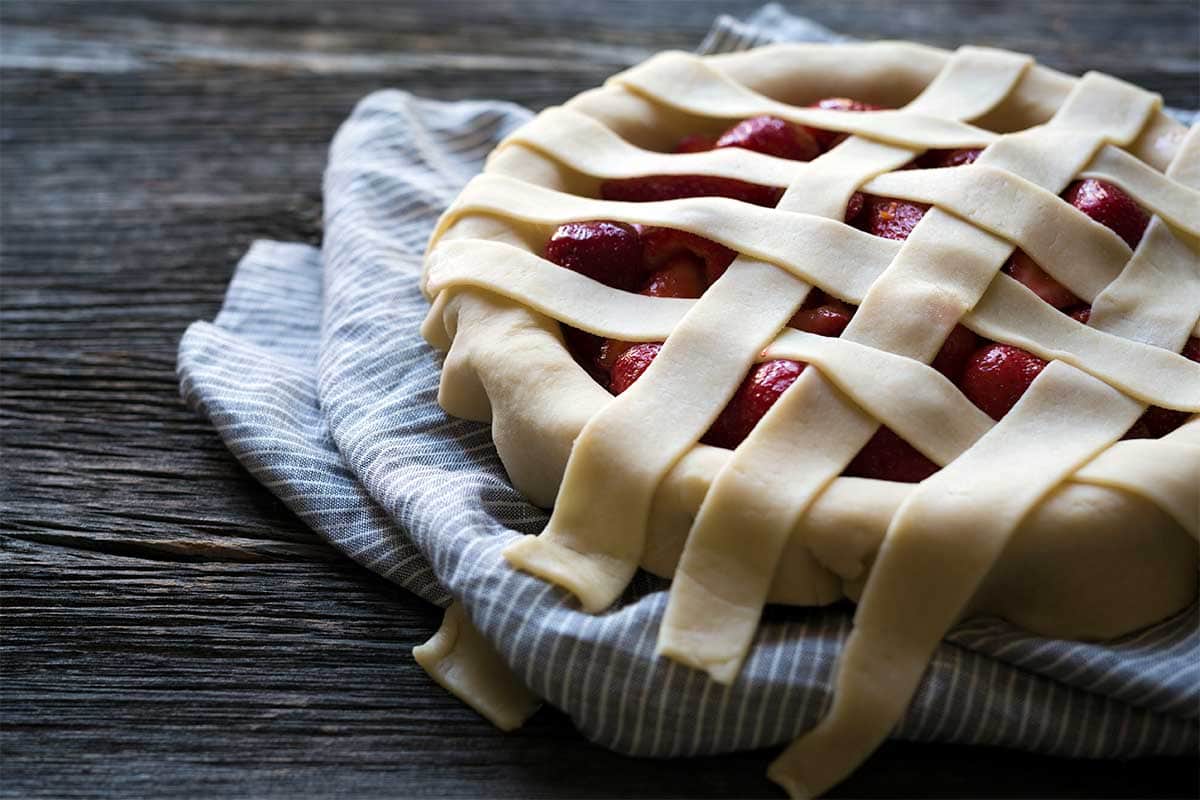 Building a lattice pie top over pie filling, using homemade dough.