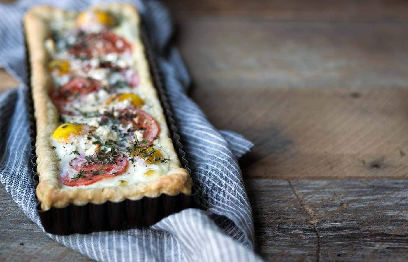 This Tomato Feta Egg Tart is perfect as an appetizer, side dish, or even for breakfast. It’s beautiful and incredibly delicious. SavorySimple.net
