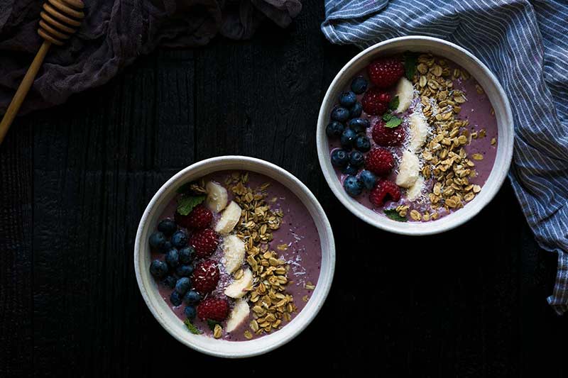 Two Acai berry smoothie bowls shot from overhead