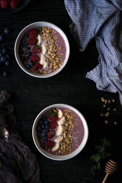Two Acai berry smoothie bowls shot from overhead
