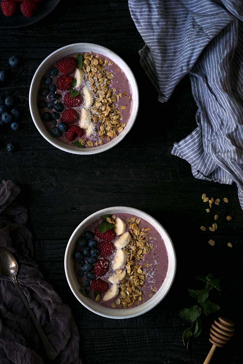 Two Acai berry smoothie bowls shot from overhead
