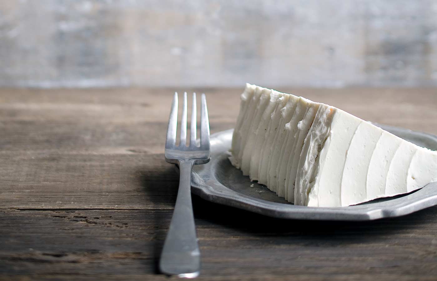 A slice of layer cake frosted with Italian Meringue Buttercream