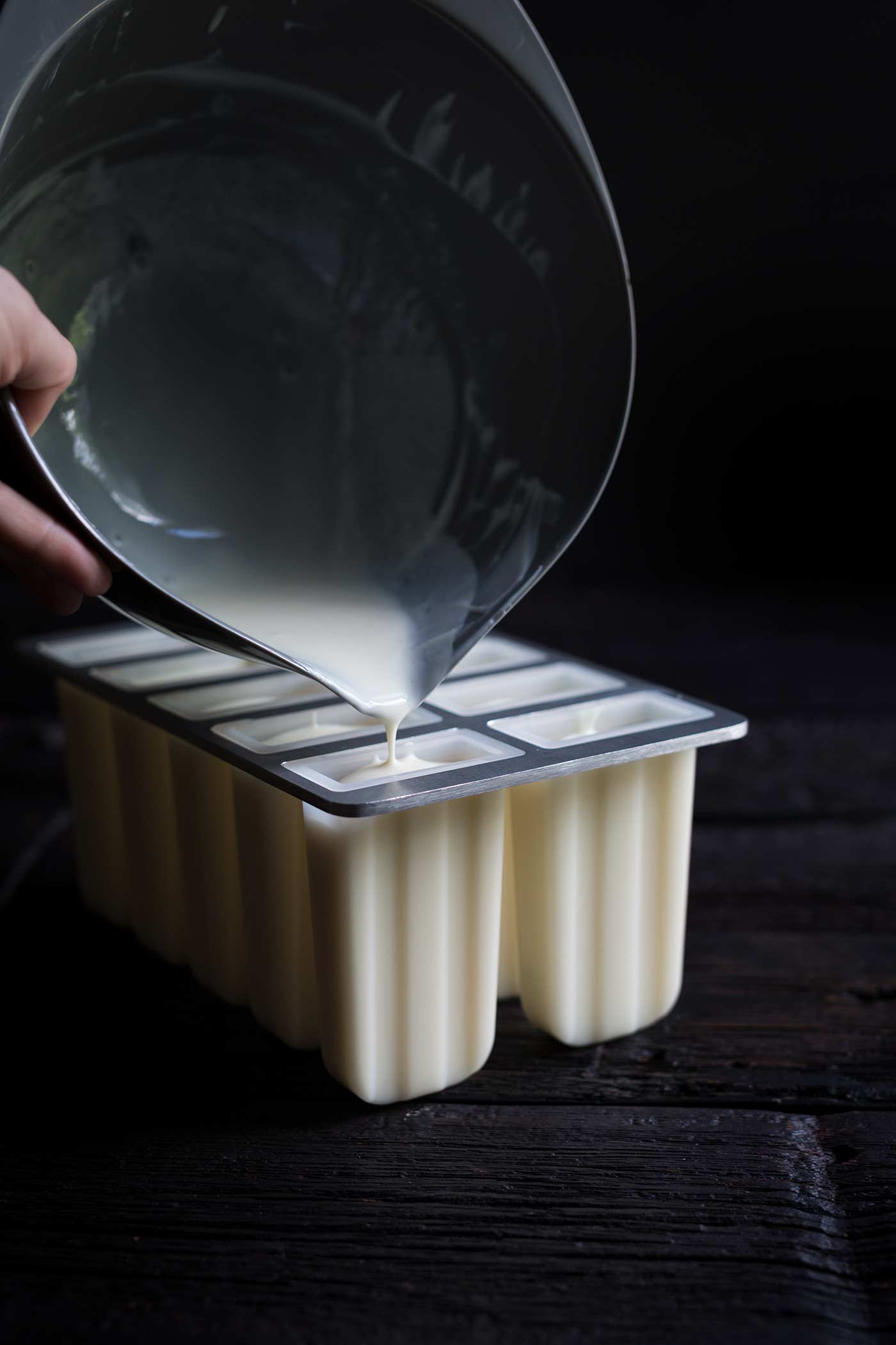 A photo demonstrating the filling being poured into popsicle molds
