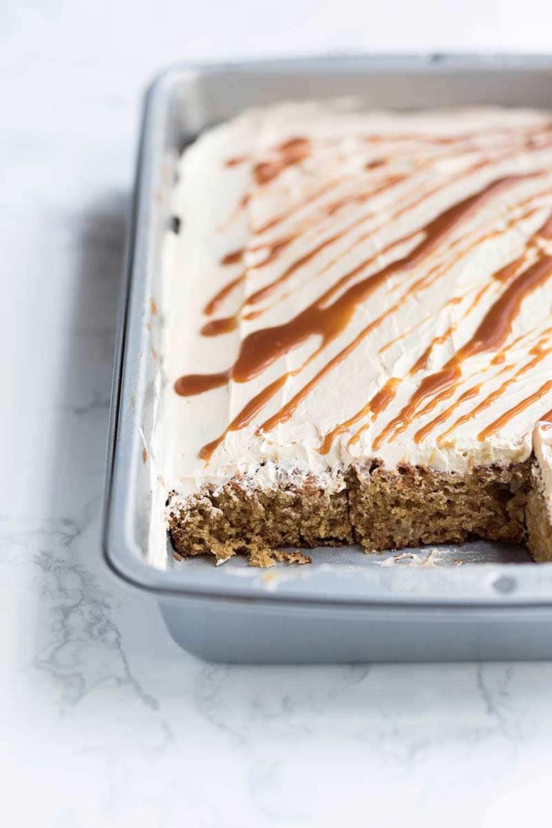 Salted Caramel Apple Cake recipe in a 9x13 pan with several slices missing