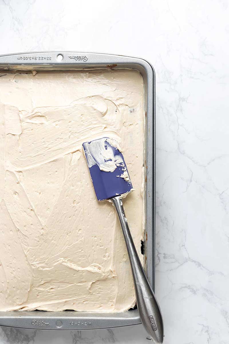 A photo of freshly frosted Salted Caramel Apple Cake.