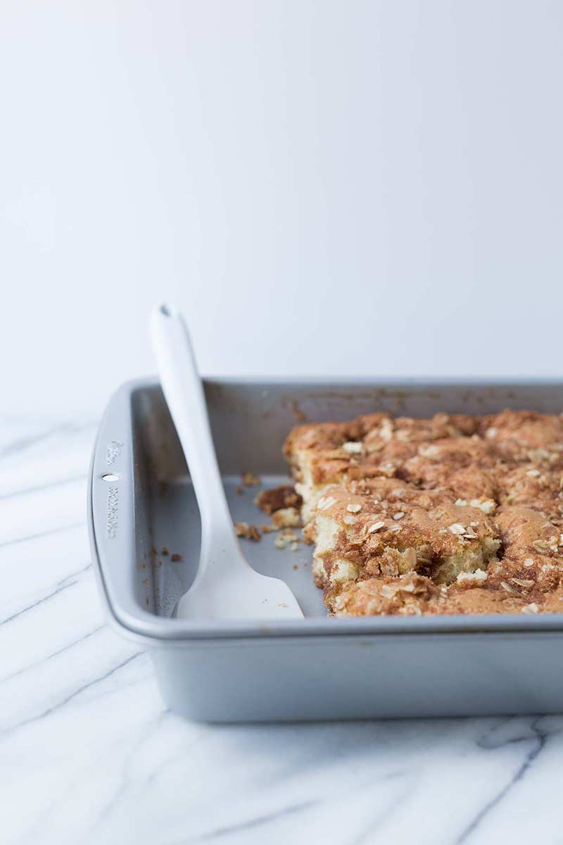 white serving spatula in baking pan with cinnamon streusel coffee cake
