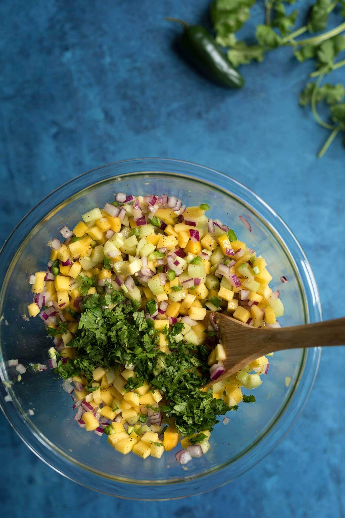 A photo of the ingredients for mango salsa about to be combined in a mixing bowl.