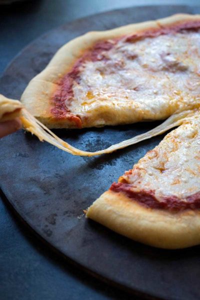 A photo of homemade frozen pizza with melted cheese oozing off a fresh slice.