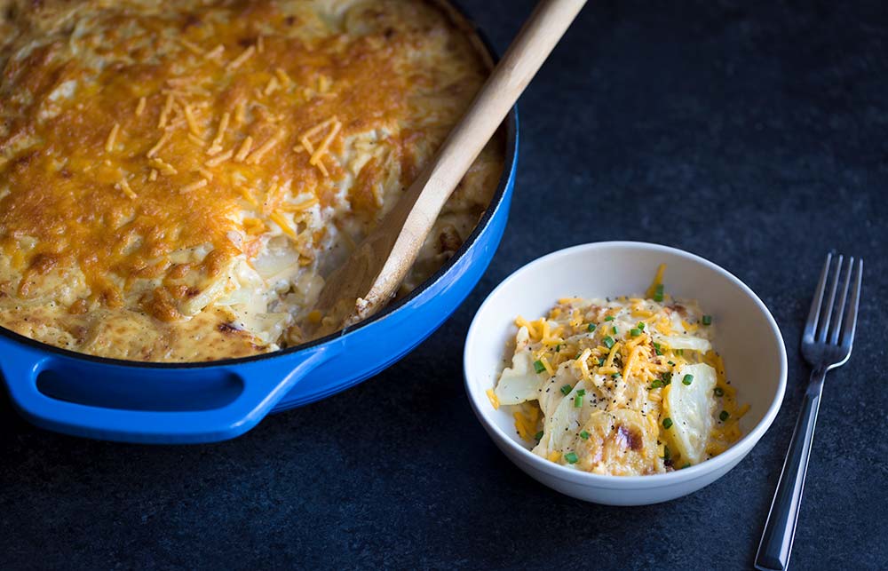 A photo of the cheesiest potatoes au gratin, straight out of the oven, served in a bowl.