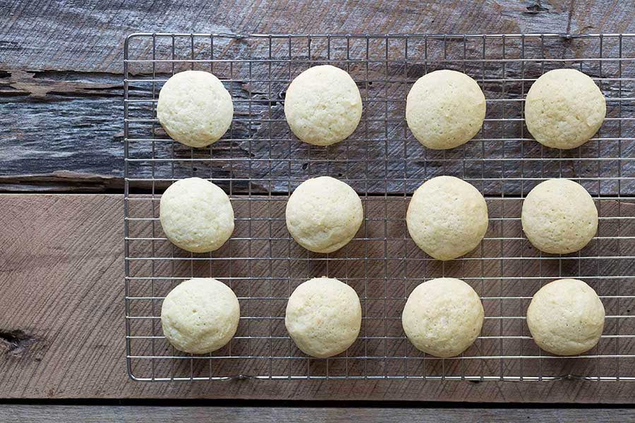 A photo of egg nog cookies cooling on a wire rack, ready to be frosted with eggnog cookie icing.