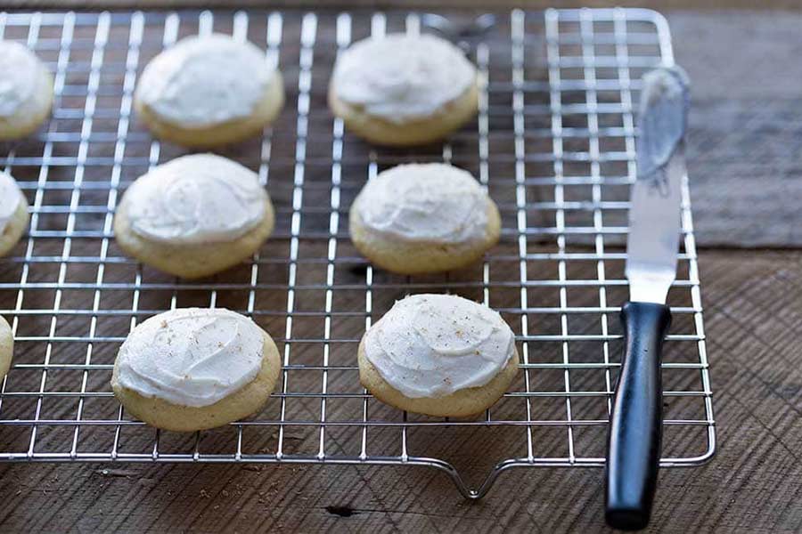 A birds eye shot of frosted eggnog cookies on a wire rack.