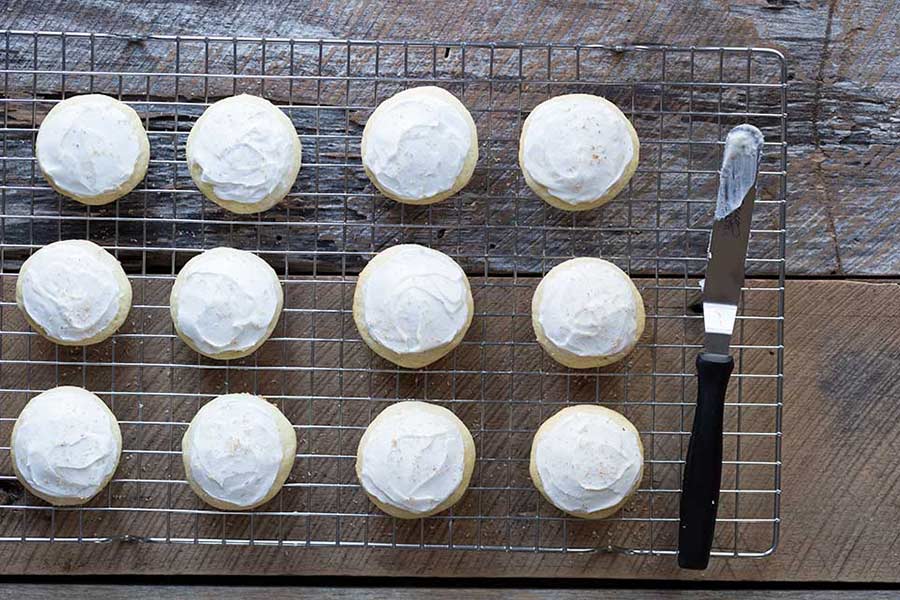 An overhead shot of frosted eggnog cookies topped with freshly grated nutmeg.