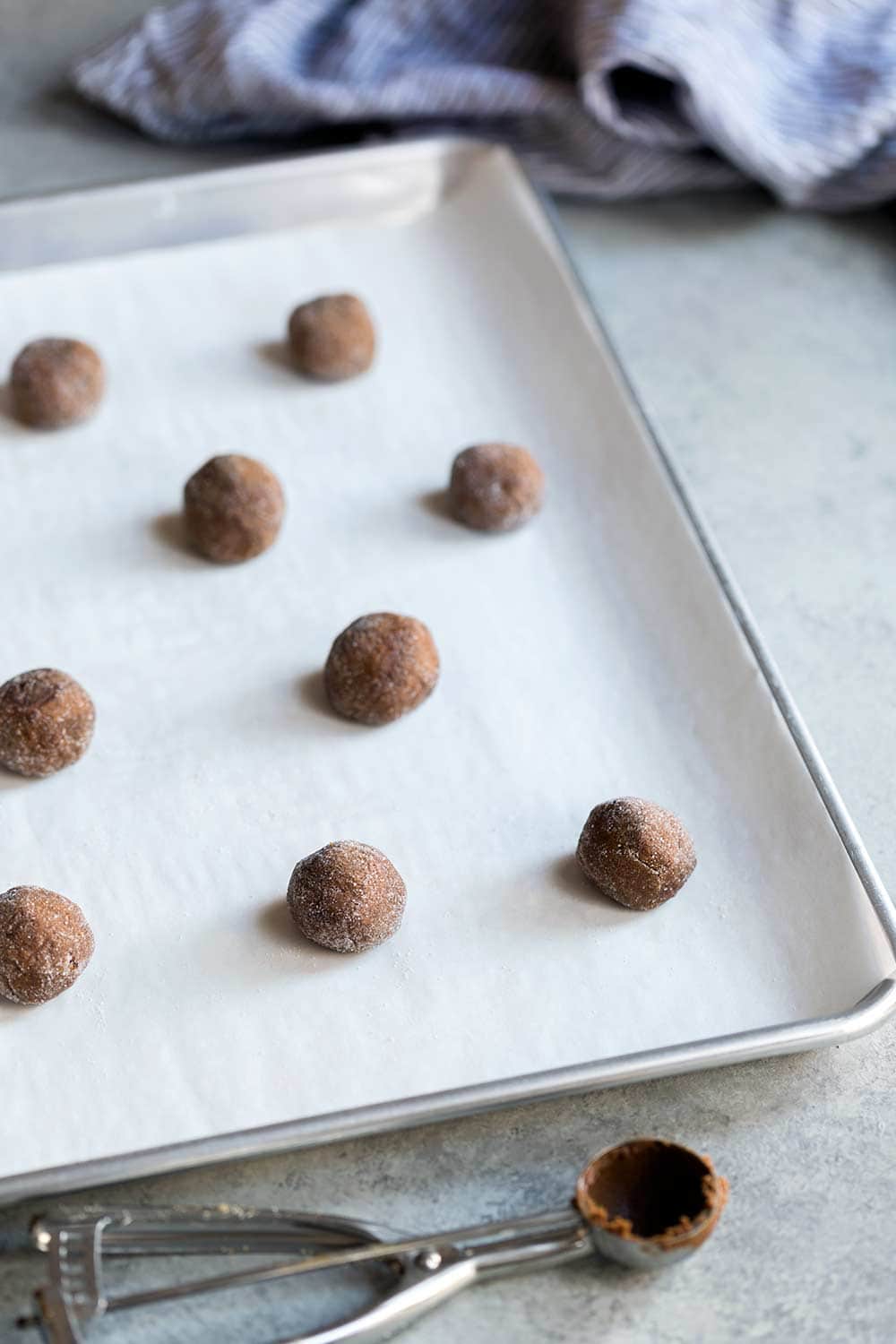 Gingerbread cookie dough scooped into balls on a cookie sheet