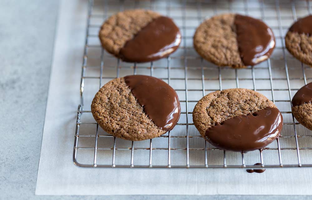 Chocolate dipped gingerbread cookies cooling on a cookie rack