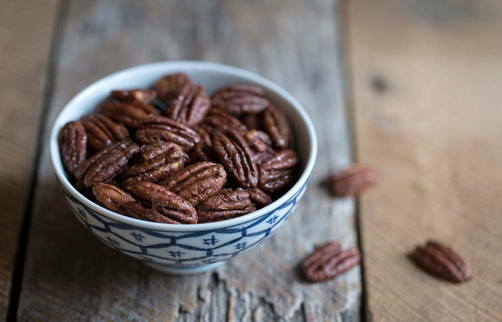 A close up photo of candied pecans.