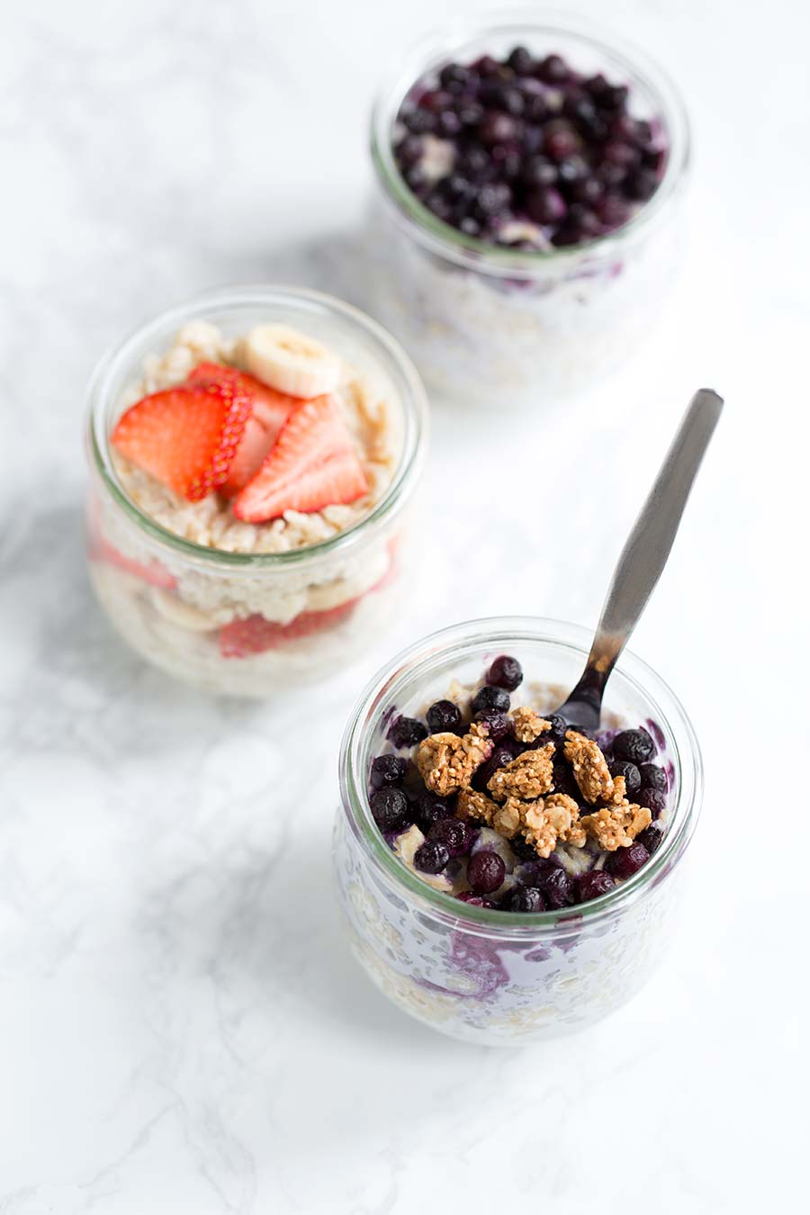 An overhead view of overnight oats, highlighting blueberries and granola.