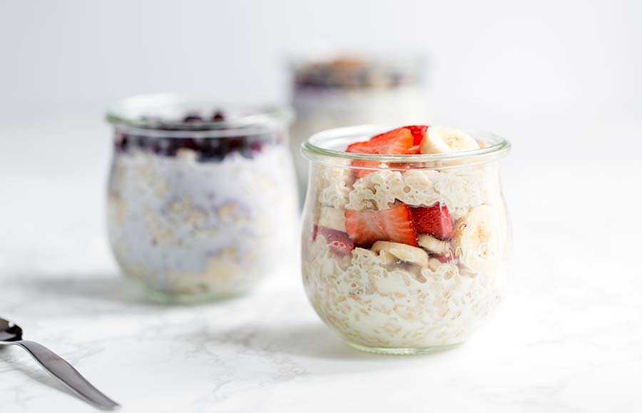 A close up of overnight oats in a jar mixed with strawberries and bananas.
