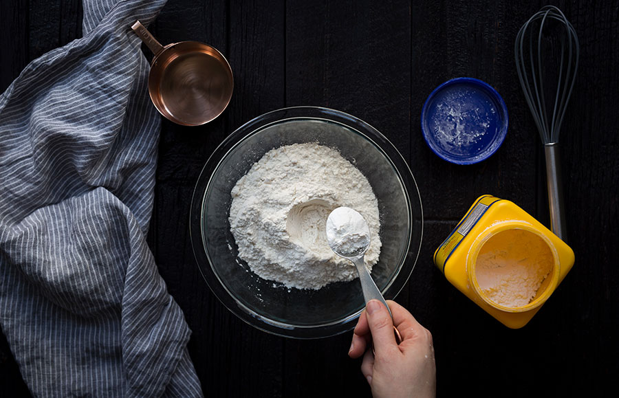 A photo of flour in a bowl with 1 tablespoon of cornstarch being added.