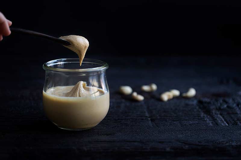 A photo of homemade nut butter on a spoon.