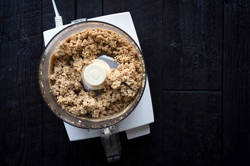 raw unsalted nuts being processed into butter in a food processor