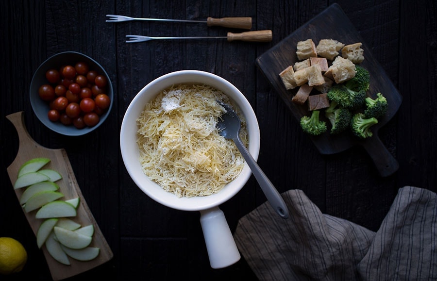 A photo of grated cheese in a fondue pot.