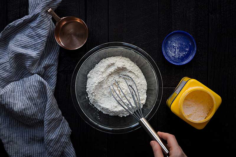 A bowl of flour being whisked.