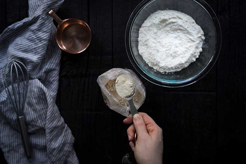A tablespoon of vital wheat gluten being spooned from the bag.
