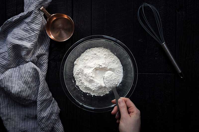 A photo of AP flour in a bowl with 1 tablespoon being removed.