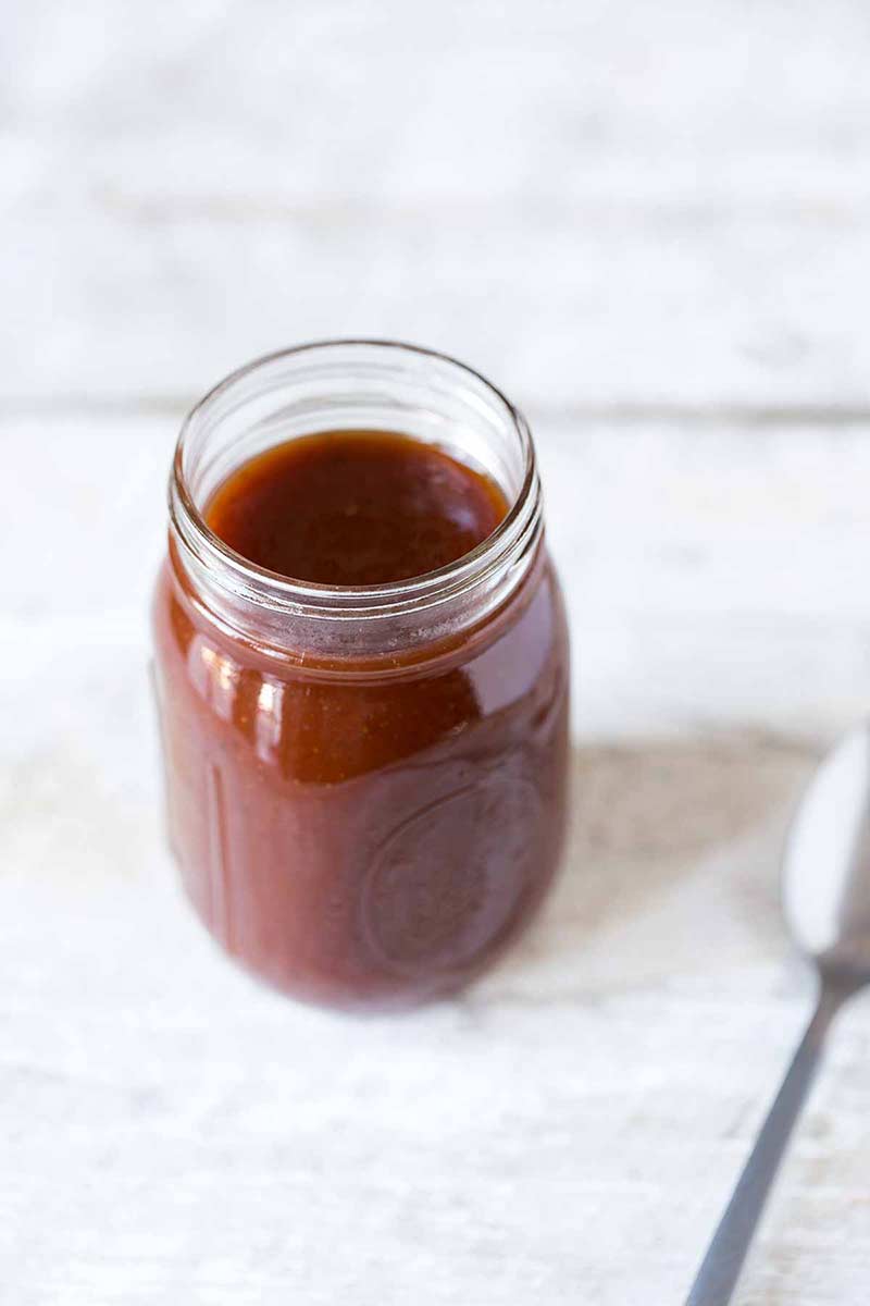 Homemade barbecue sauce recipe in mason jar with a spoon