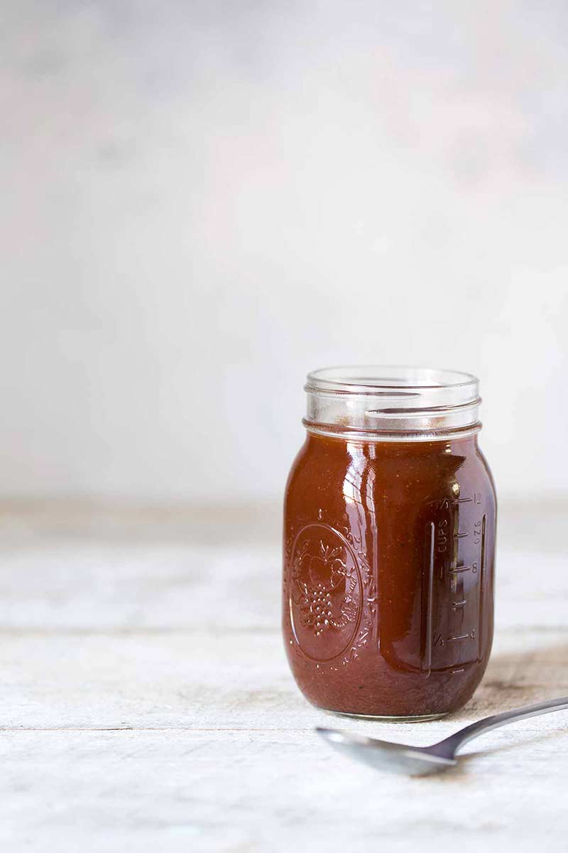 sweet and spicy barbecue sauce in jar next to spoon