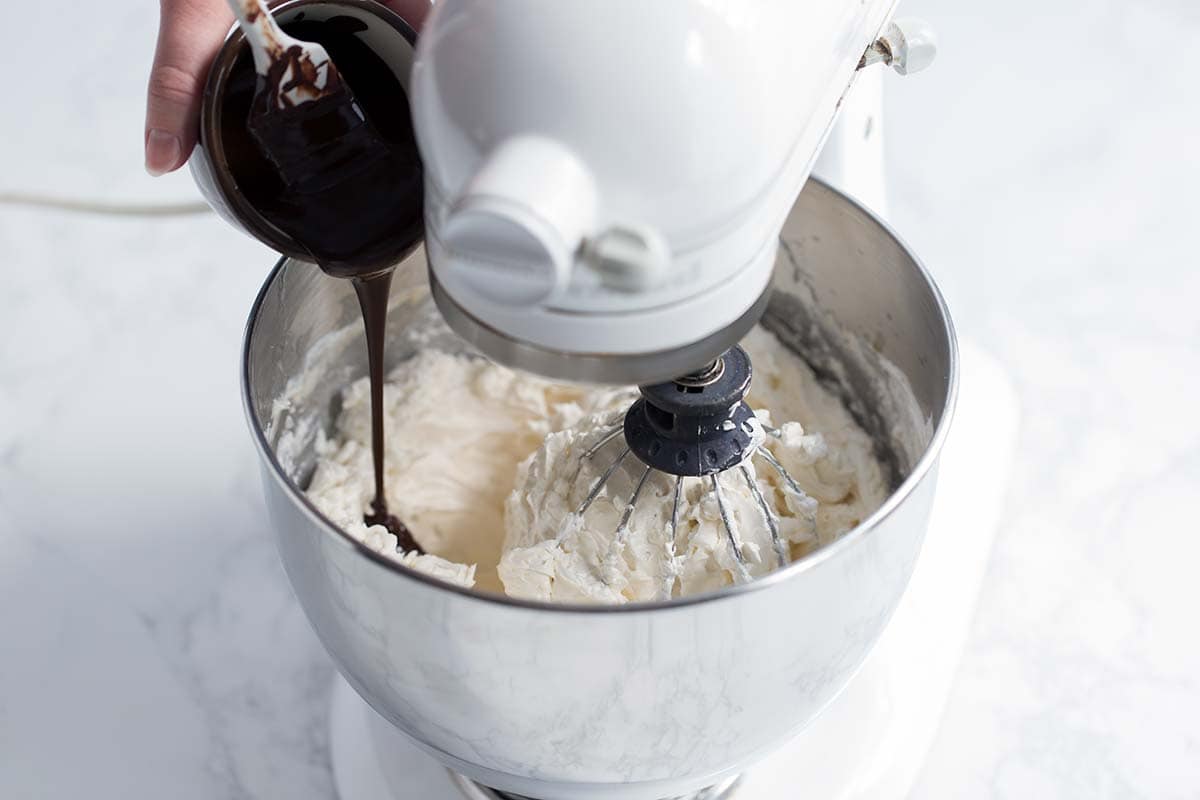 Adding melted chocolate to meringue buttercream.