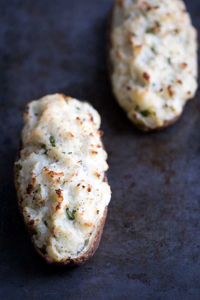 Twice-Baked Potatoes, golden brown on top from a hot oven, sitting on a baking sheet