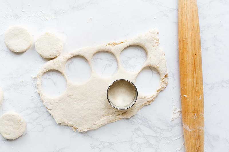 Biscuit dough rolled out with a rolling pin, then cut into with a round cutter.