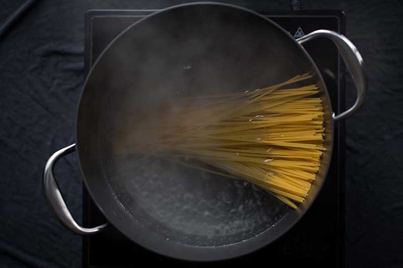 Dry pasta added to a pot of boiling water