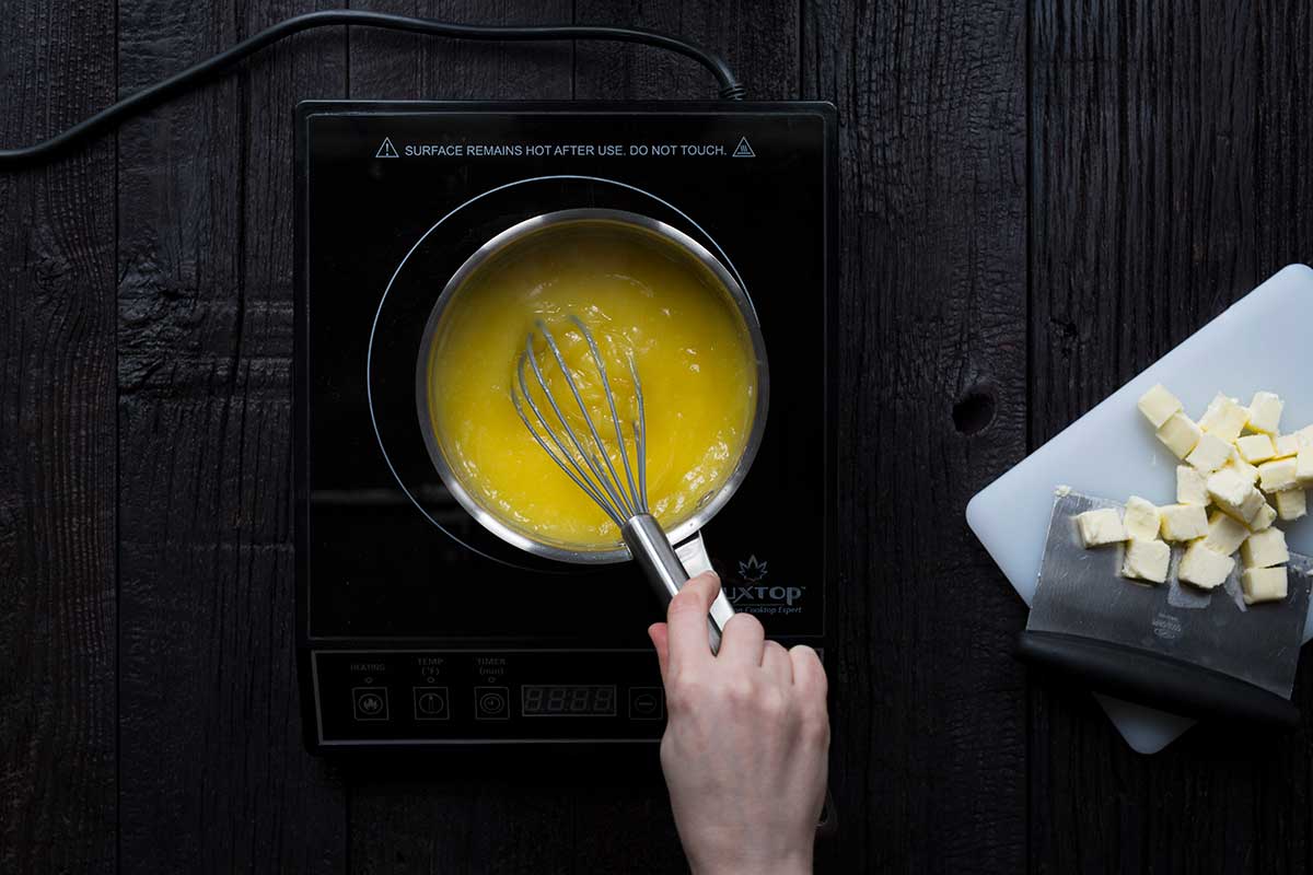 Whisking the lemon curd ingredients together until thick.