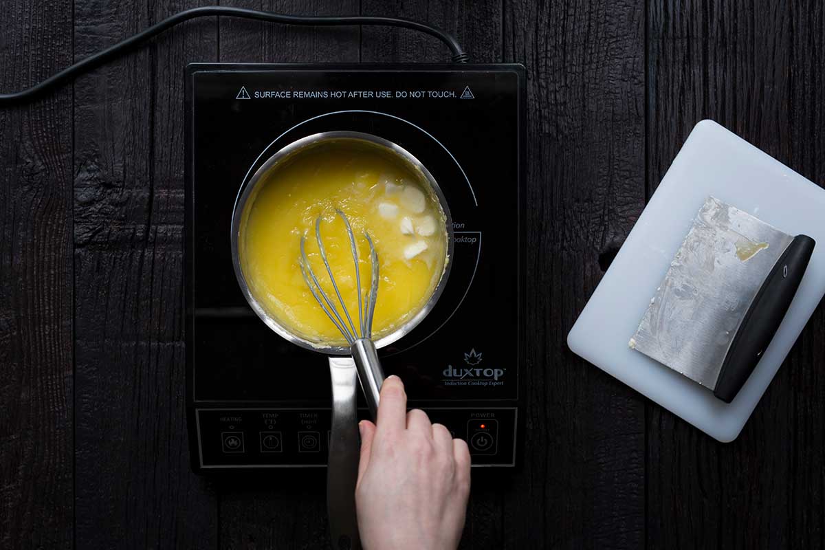 Adding butter to the lemon curd recipe.