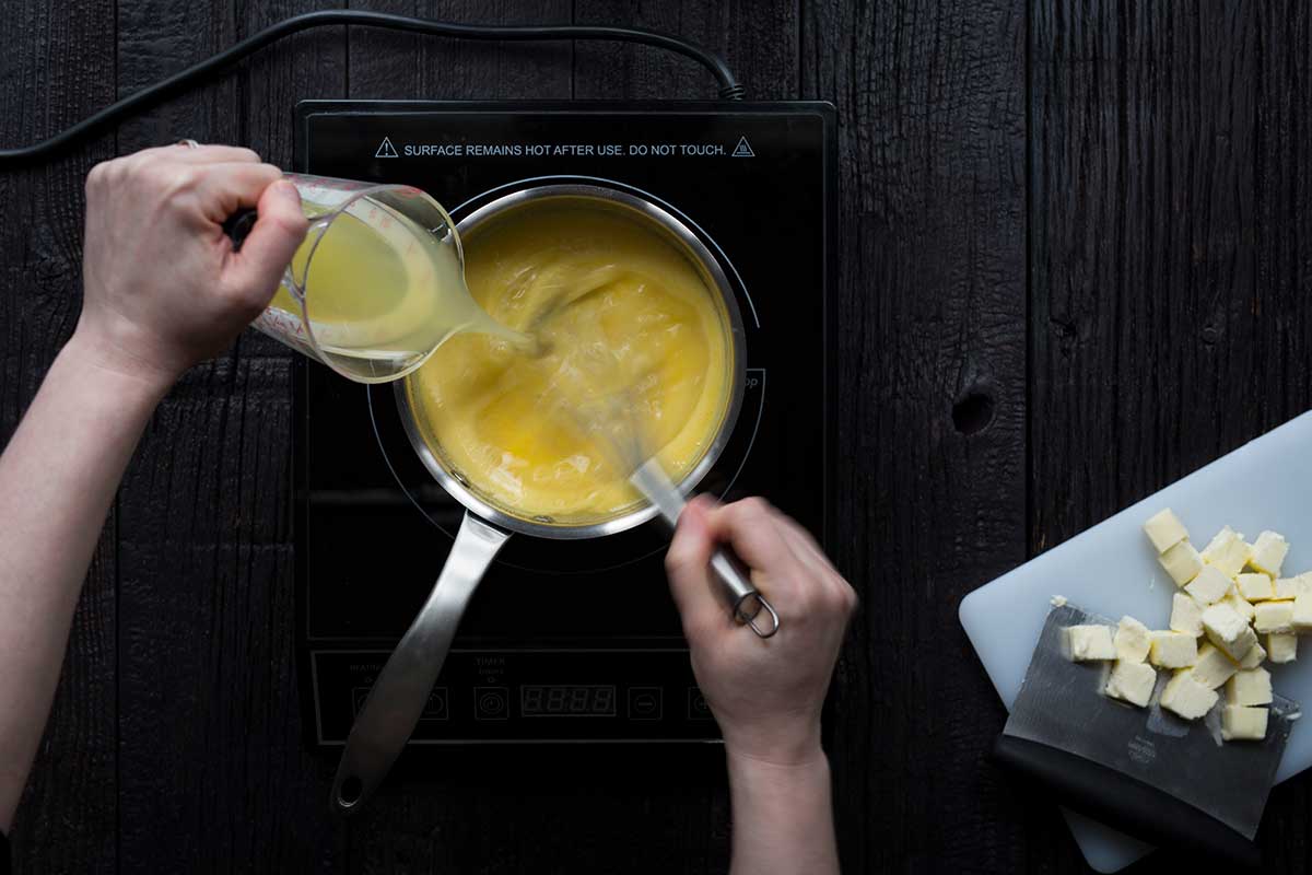 Whisking the lemon juice into the saucepan.