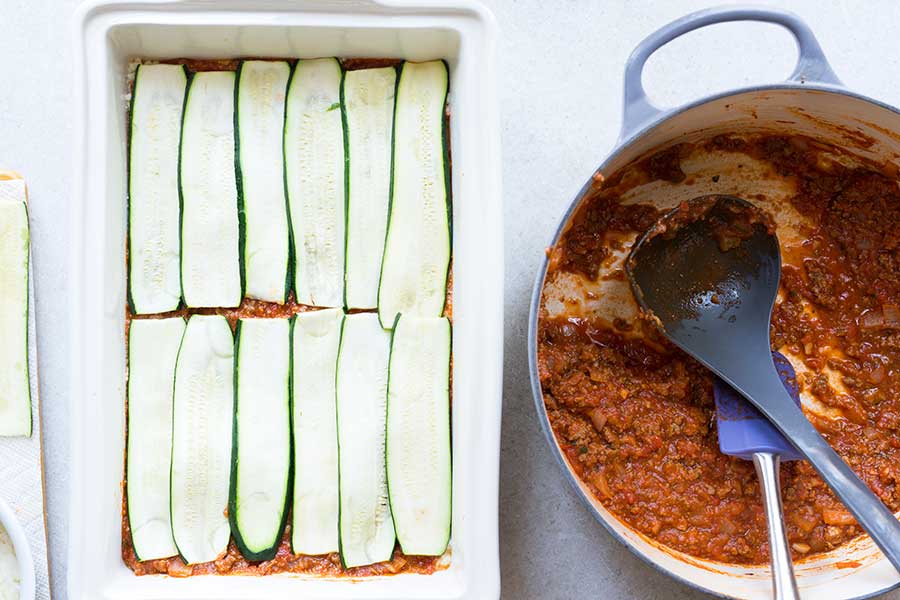 layering zucchini noodles onto lasagna
