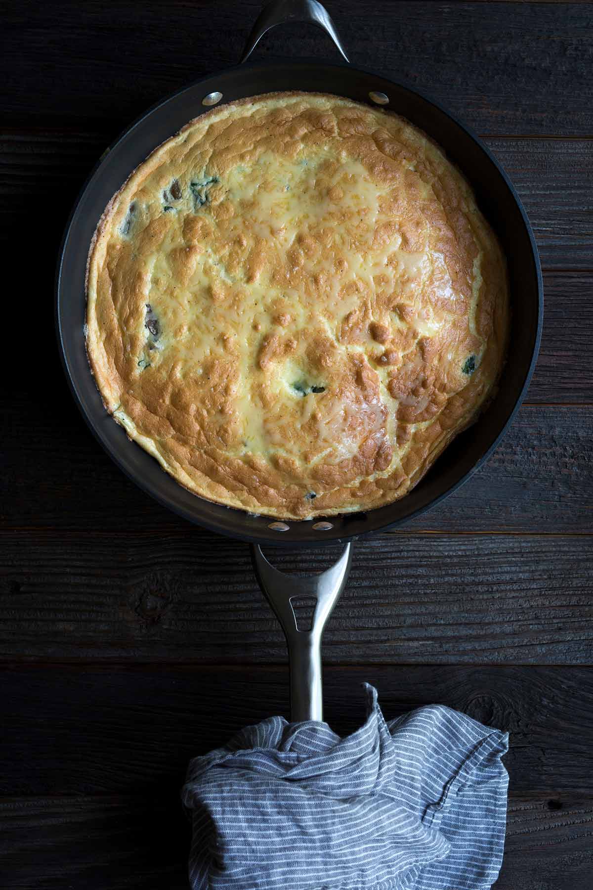 A Swiss, Mushroom and Spinach Frittata in a nonstick skillet.